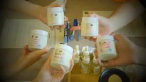 Multiple scented coco-soy candle jars held up at once after making blends at Perfume Play in Singapore candle workshop