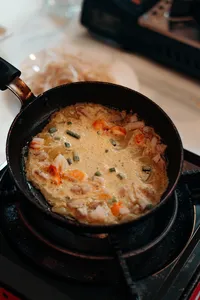 在会安 Jolie Cooking Class 的课堂烹饪中，虾和蔬菜正在炉灶上的锅里慢炖