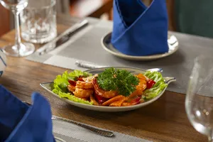 Four-course-style seafood lunch on a Cat Ba boutique cruise, with shrimp and herbs served at a wooden table