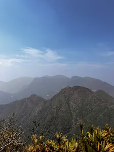 Mountain ridges under a clear blue sky with misty layers beyond, captured during a 1-day eco trek at Mt Fansipan