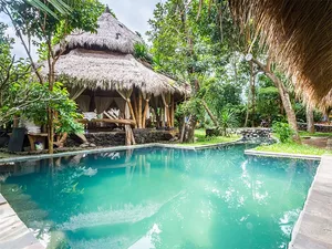 Thatched-roof cottages beside a calm garden pool at Omunity Bali in Bali for a 3D2N sacred meditation stay