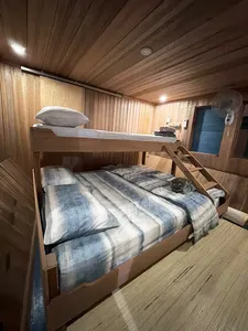 Air-conditioned houseboat cabin with wooden walls and neatly made beds on a 4D3N orangutan safari in Tanjung Puting
