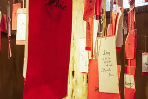 Hanging red and gold gift bags with Vietnamese writing inside a shop for an agarwood tour in Hanoi