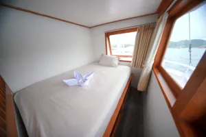 Travass Life 3D2N join-in Komodo trip cabin bed with folded towel swan and window sea views, Labuan Bajo