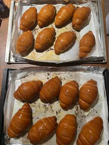 Glazed shio pan rolls filling two parchment-lined trays as they cool after baking during workshops in Singapore