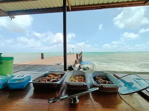 Diving gear laid out on the deck at Luma Selakan sea lodge, Semporna, with turquoise water and open horizon beyond