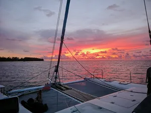 View from a yacht deck at sunset over the sea in Malaysia, with sail rigging and calm waters