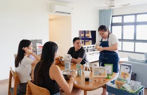 Baking class in a bright kitchen: participants prepare ingredients and drinks while the host demonstrates shio pan—workshops in Singapore