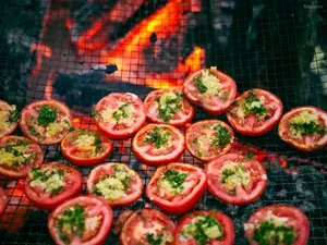 Halved tomatoes with herbs grilling on a camp barbecue during a 2D2N Tibetan valley stay with Caravan Treks by Ferme Liotard in Shangri-La