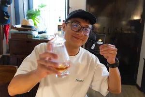 Scotch & Sambal host-led whisky tasting in Singapore: a man smiles while holding a dram glass at the hidden home bar