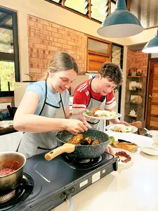 People cooking Malaysian comfort food in a farmhouse kitchen at Kebun Lidstari permaculture farmstay, Langkawi