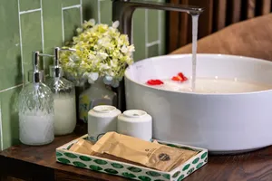 Toiletries and a white bath basin on a wooden table in Cat Ba Ocean Cruises’ cabin for the 3D2N Cat Ba cruise