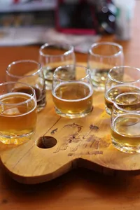 Selection of small glasses of amber tea on a wooden board for a Tibetan tea tasting ceremony in Shangri-La