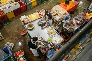 Orang-orang menangani lapak ikan dan makanan laut di pasar ikan pelabuhan Jurong yang ramai di Singapura selama tur berpemandu