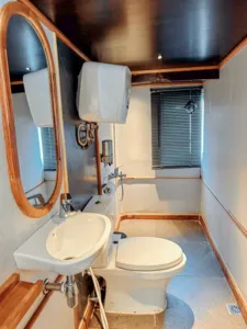 En-suite cabin bathroom with white sink and toilet, compact fixtures on a deluxe phinisi in Labuan Bajo