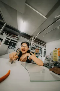 Tan Sock Fong beams while holding a torch for a glass centrepiece workshop at Art Glass Centre, workshops in Singapore