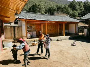 Walkway in a courtyard as trekkers head from a village house towards the mountains near Lijiang on the Yi & Naxi trek