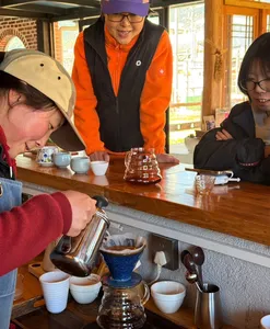 Tasting session at a coffee workshop in Lijiang as guests pour and brew Yunnan specialty coffee from a glass siphon brewer