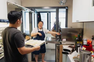 Instructor at a stainless baking station demonstrating shio pan dough while participants watch during hands-on bread workshops in Singapore