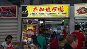 Singapore hawker stall frontage with a large rojak sign above the kitchen counter and customers queuing inside — Singapore hidden gems