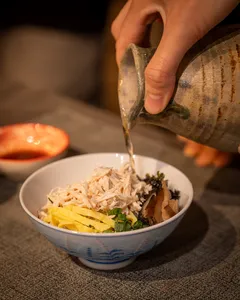 Primateve host pours hot broth over a Japan-inspired grazing platter bowl during private dining Singapore