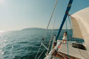 Cosy sailing on a catamaran from Kota Kinabalu, with a person on deck watching the waves under the sail rigging