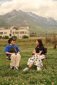 Family-run coffee workshop in Lijiang: Seeker Yunnan Coffee Estate host chatting with a guest among blooming fields and peaks