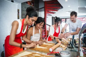 Hands shaping croissant dough on wooden boards in a Singapore kitchen with a French Cooking Lab group, workshops in Singapore