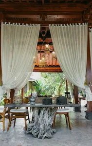 Outdoor tables under hanging lanterns with white curtains at The Kitchen Garden Bajo for Traditional Manggarai vegan cooking, Labuan Bajo