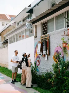 Tour group walking past colourful shophouses and wall art on Joo Chiat streets during a food tour, Singapore hidden gems