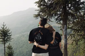 Couple embracing with their backs to the camera, overlooking misty mountains in Ha Giang on the Ha Giang loop