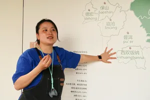 Seeker Yunnan Coffee Estate guide in Lijiang explaining Yunnan’s coffee-growing regions with a wall map
