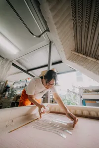 Art Glass Centre Singapore studio: a glass artist gently shaping a centrepiece with hands and tools amid surfaces — workshops in Singapore