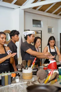 Apron-clad participants learning Indonesian cooking on Gili T in Lombok, hands working at sauce and spice stations