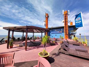 Sunset deck of a retired oil-rig dive base with loungers, orange pipework and sea views off Semporna, Seaventures