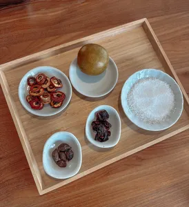 Bowls of dried Chinese-medicine ingredients and powders on a wooden tray for TCM mocktail making workshops in Singapore