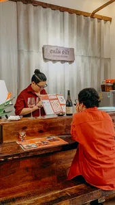 Host and guests sit at a wooden counter at Chan Dat Living Room in Hoi An, sharing a guided Deep Cultural Tasting
