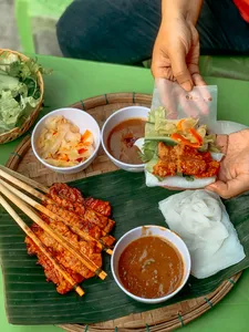 Kulit popia Vietnam sedang disediakan dengan sos pencicah dan sate panggang di Chan Dat Living Room, Hoi An