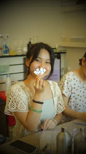Participant holding scent sample cards while preparing personalised coco-soy candle blends at Perfume Play in Singapore candle workshop