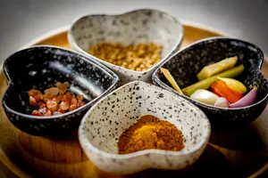 Forage-to-table cooking class ingredient bowls with spices, herbs and vegetables on a wooden table in Mae Kampong, Chiang Mai