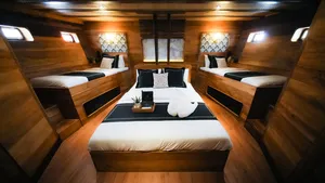 Twin cabin interior on Angelica Liveaboard with neatly made beds and a central table, onboard a 3D2N luxe Komodo cruise in Labuan Bajo