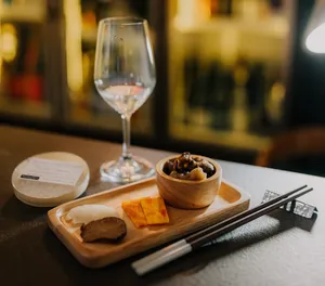 Sake tasting set-up in a tucked-away Singapore shop: crystal glasses, chopsticks and small dishes on a wooden board