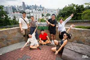 Friends posing at a hilltop viewpoint overlooking Singapore skyline after a Mount Faber war ruins walk — Singapore hidden gems