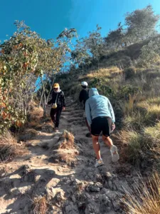 Hikers following a rocky trail through dry scrub vegetation during an island trek from Labuan Bajo to Komodo Island