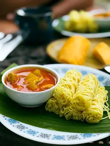 Bowls of Malaysian curry with noodles on a banana leaf at Kebun Lidstari farmhouse dining in Langkawi
