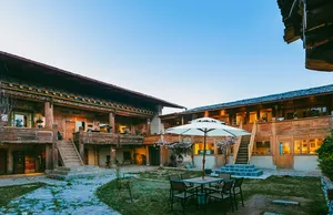 Courtyard at Ferme Liotard in Shangri-La, a Tibetan-style lodge with umbrella dining table and snow-dusted flagstone garden
