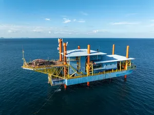 Retired oil rig turned dive base, the Seaventures Dive Rig floating offshore in the blue sea near Semporna