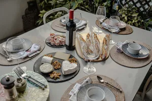 French baguette meal spread on a dining table in a cosy Singapore loft, with wine bottle and plates for sunset drinks