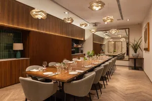 Wood-panel dining room with laid tables for served meals after a Singapore cooking session, private dining Singapore