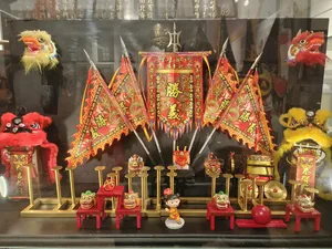 Lion dance heritage shop window display with colourful ceremonial banners, lion head figurines and props arranged behind glass